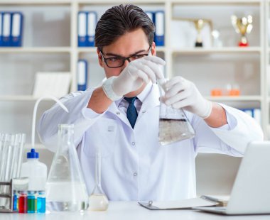 Genç araştırmacı bilim adamı bir su testi kirliliği araştırması yapıyor.