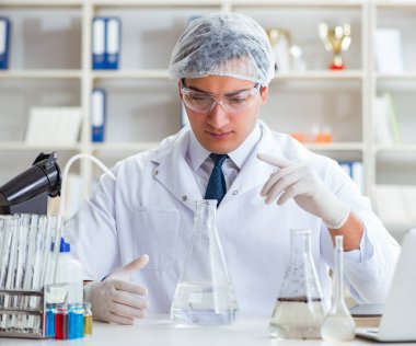 Genç araştırmacı bilim adamı bir su testi kirliliği araştırması yapıyor.