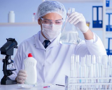 Laboratuvardaki adam yeni temizlik çözeltisi deterjanı test ediyor.