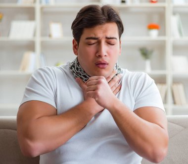 Genç adam boğaz ağrısı çekiyor.