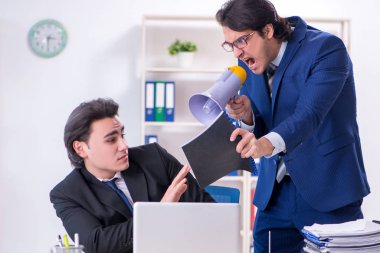 Patron ve erkek asistanı ofiste çalışıyor.