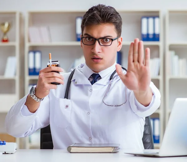 Médico masculino en concepto anti-tabaquismo con paquete de cigarrillos — Foto de Stock