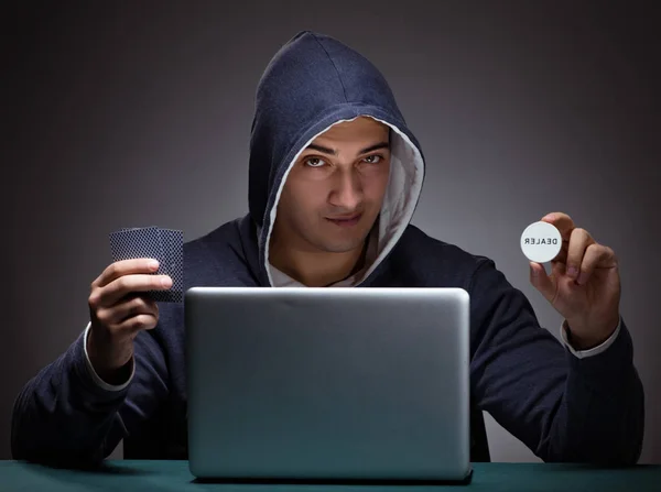 Junger Mann mit Kapuzenpullover sitzt vor einem Laptop — Stockfoto