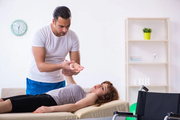 Mujer joven que visita al médico fisioterapeuta masculino —  Fotos de Stock