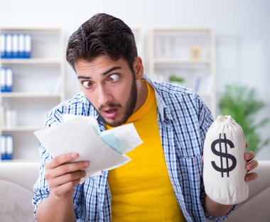 Ödeme yapması gereken faturalara kızgın bir adam.