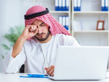 Ofiste çalışan Arap işadamı bir Pi ile evrak işi yapıyor.