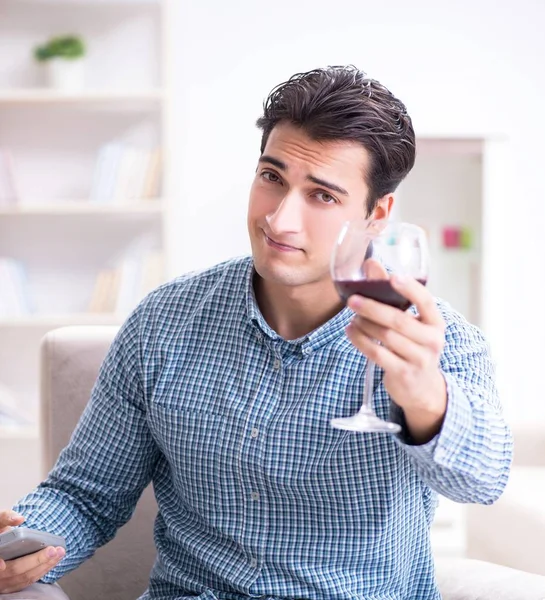 Молодий чоловік п'є вино вдома — стокове фото