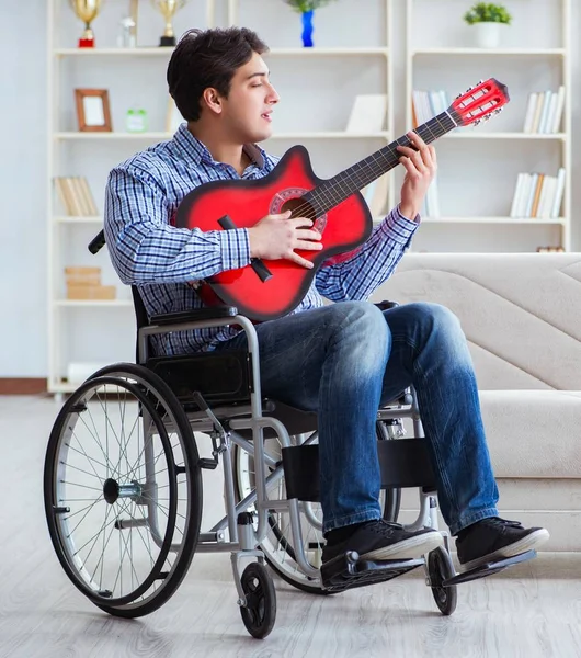 Handikappad man spelar gitarr hemma — Stockfoto