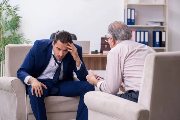 Young man visiting old male doctor psychologist — Stock Photo, Image