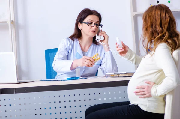 Mujer embarazada joven que visita médico experimentado ginecólogo — Foto de Stock