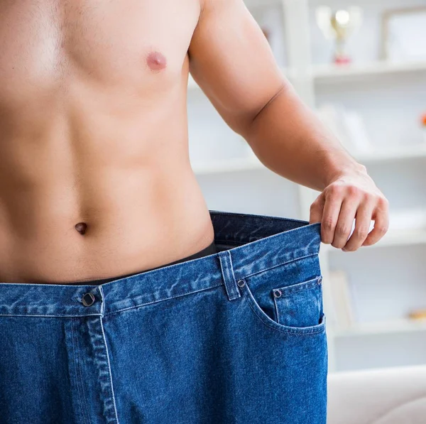 Hombre en pantalones de gran tamaño en concepto de pérdida de peso — Foto de Stock