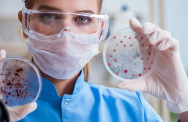 Bir laboratuarda deney yapan kadın bir bilim adamı.