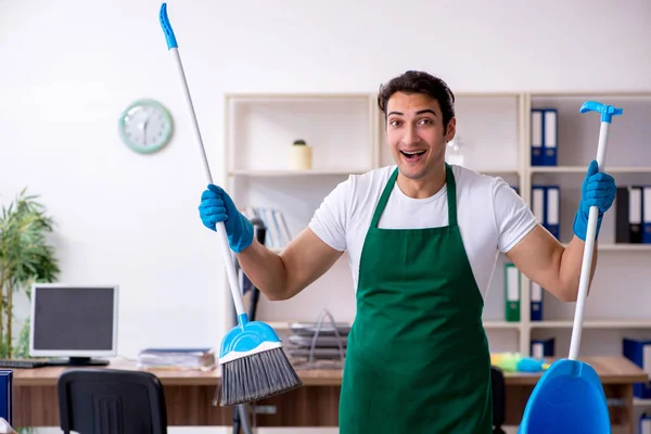 Jonge knappe aannemer schoonmaken van het kantoor — Stockfoto