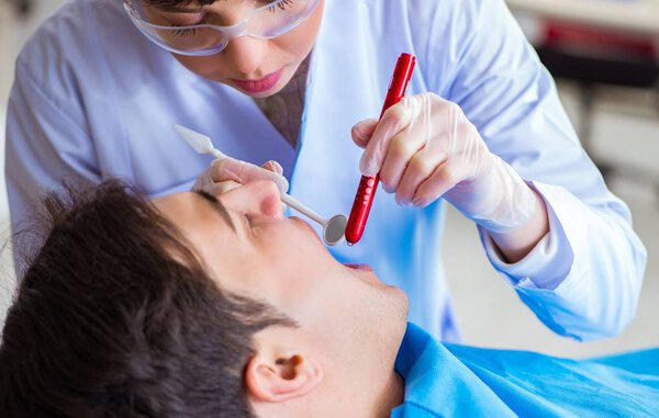 Woman dentist doctor with male patient in hospital