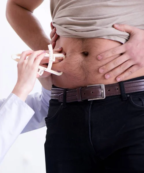 Médico dietista dando consejos a pacientes con sobrepeso de grasa — Foto de Stock