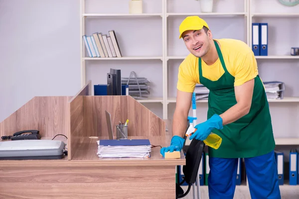 Jovem empreiteiro limpando o escritório — Fotografia de Stock