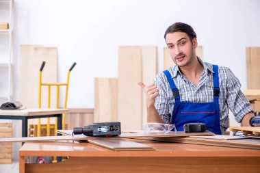 Genç erkek marangoz içeride çalışıyor.