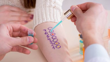 Hastanedeki hastanın alerji reaksiyonunu test eden doktor.