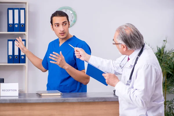 Due medici che parlano alla reception in ospedale — Foto Stock