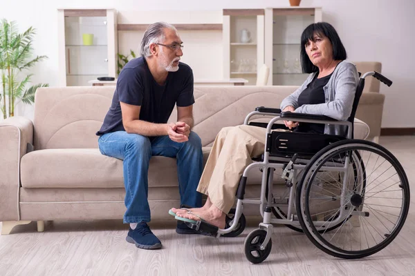 Oude man zorgt voor gehandicapte vrouw — Stockfoto