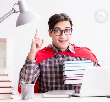 Dizüstü bilgisayarı olan süper kahraman öğrenci sınavlara hazırlanıyor.