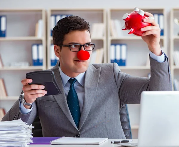 Clown-Geschäftsmann mit Sparschwein macht Buchhaltung — Stockfoto