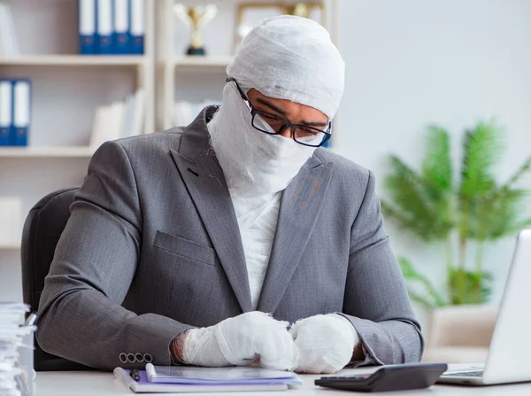 Bandażowany pracownik biznesowy pracujący w biurze wykonujący papierkową robotę — Zdjęcie stockowe