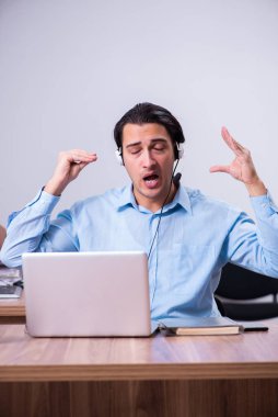 Masasında çalışan çağrı merkezi operatörü.