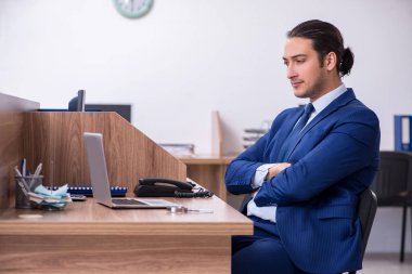Genç yakışıklı işadamı ofiste çalışıyor.