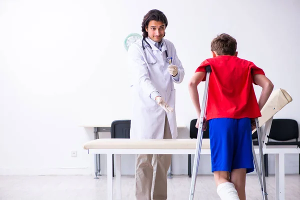Láb sérült fiú látogató fiatal orvos traumatológus — Stock Fotó