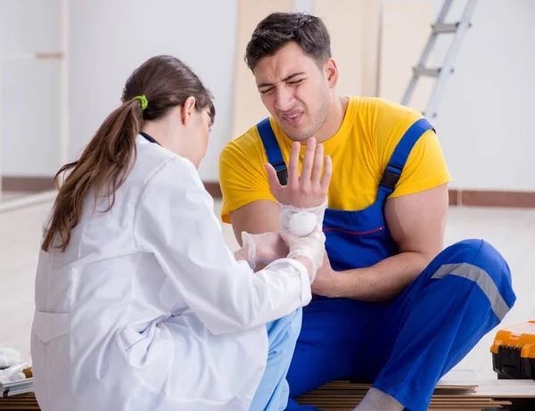 Injured worker being assisted by doctor — Stock Photo, Image