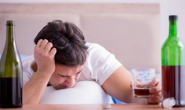 Yatakta içen alkolik adam depresyona giriyor.