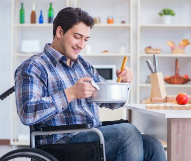 Engelli adam mutfakta çorba hazırlıyor.