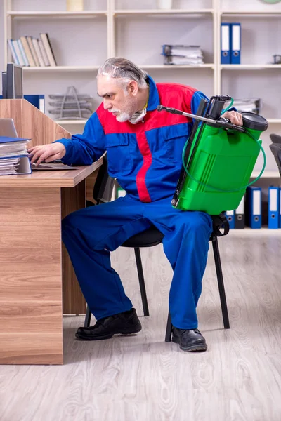 Velho empreiteiro profissional fazendo controle de pragas no escritório — Fotografia de Stock