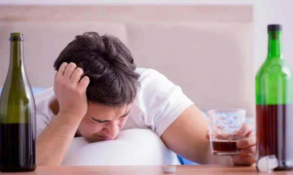 Hombre alcohólico bebiendo en la cama pasando por romper la depresión —  Fotos de Stock