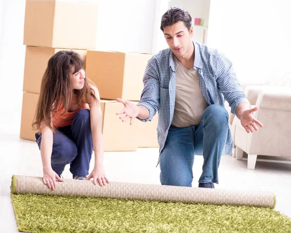 Fiatal család gördülő szőnyeg az új lakás — Stock Fotó