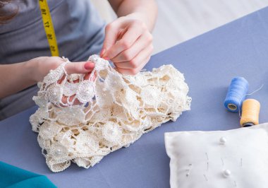 Kadın terzi dikiş dikmek için dikiş dikiyor.