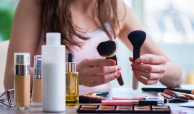 Güzellik konseptinde makyaj malzemeleri olan bir kadın.