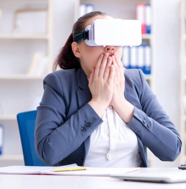 Sanal gerçeklik gözlüklü iş kadını ofisinde.