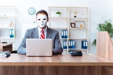 İkiyüzlülük konseptinde maske takan bir iş adamı