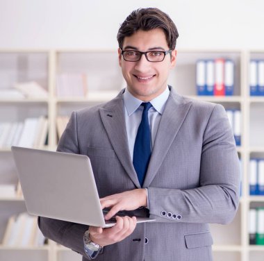 Ofisteki iş adamı dizüstü bilgisayarla çalışıyor.