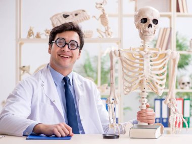 Çılgın profesör insan iskeleti üzerinde çalışıyor.