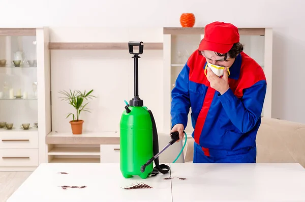 Jovem empreiteiro fazendo controle de pragas em casa — Fotografia de Stock