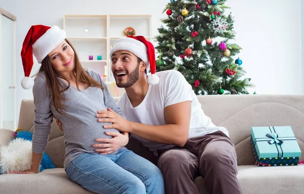 Jeune famille attend bébé célébrant Noël — Photo