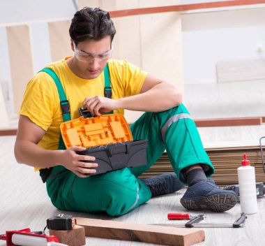 Müteahhit ahşap döşemede çalışıyor.