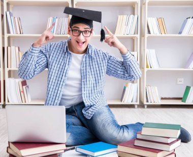 Genç öğrenci kitaplarla çalışıyor.