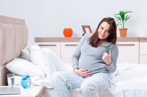 Mujer embarazada joven en el dormitorio — Foto de Stock