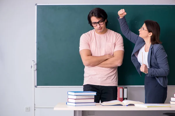 Velha professora e estudante do sexo masculino na sala de aula — Fotografia de Stock