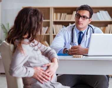 Hamile kadın muayene için doktoru ziyaret ediyor.