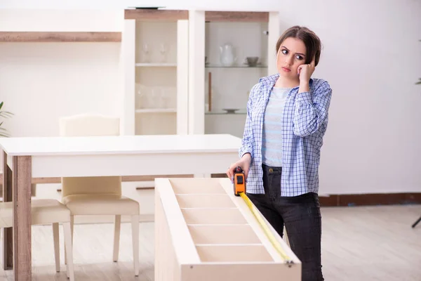 Jovem bela mulher montando móveis em casa — Fotografia de Stock